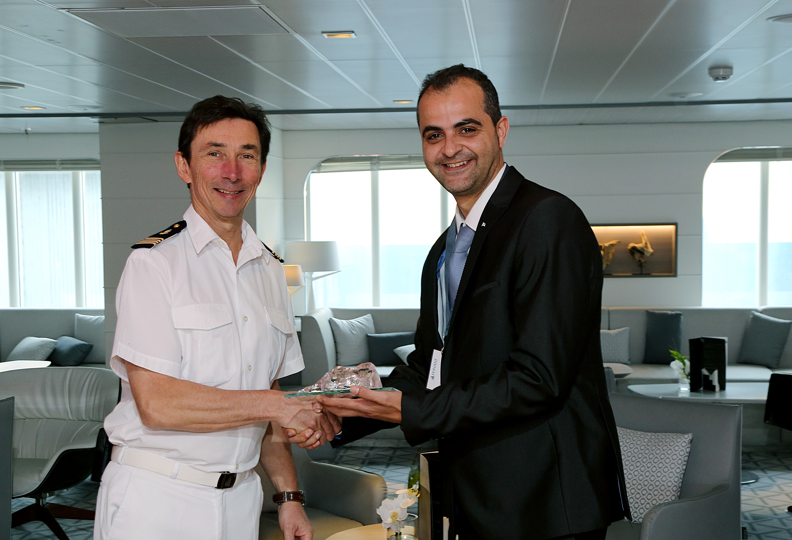 Ships Agency Manager Nico Bado, from Wilhelmsen, presents a gift to the Captain
